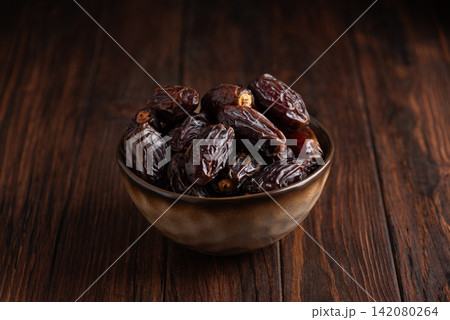 Fresh Ripe Dates in Ceramic Bowl on Dark Wooden Table Serving Healthy Natural Fruit Food Ingredient 142080264