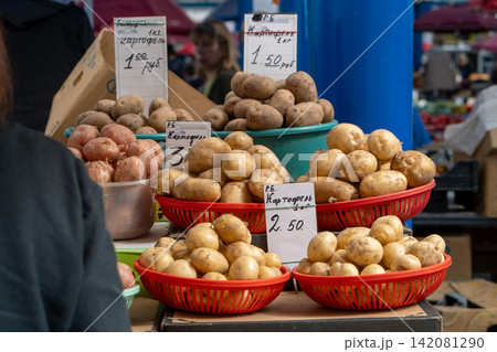 Photo showing fresh potatoes on a stand at a farmers market. Raw potatoes on the shelf in grocery store 142081290