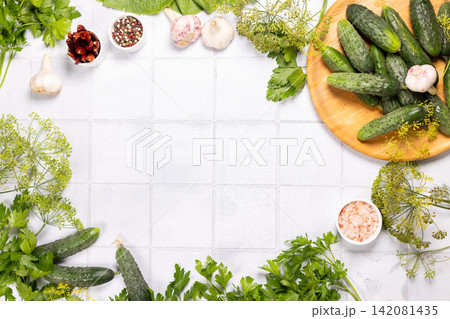 Fresh pickling ingredients on white kitchen table creating a frame Fresh pickling ingredients on white kitchen table creating a frame 142081435