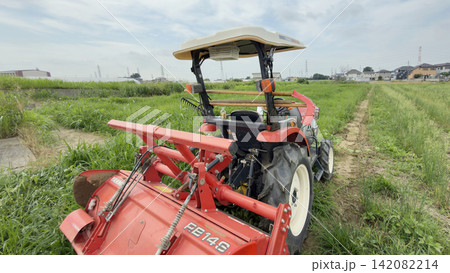 トラクターで草の畑を耕す トラクターで草の畑を耕す 142082214