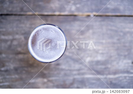 Full Glass of Beer on a Rustic Wooden Table. 142083097