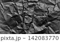 皺のついた黒い紙のテクスチャ。しわくちゃな紙の背景素材 142083770