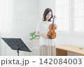 自宅でバイオリンを練習する女性　 142084003