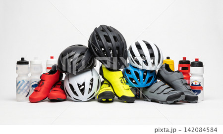 Assorted cycling gear collection including protective helmets shoes and hydration bottles on white background with accessories protection footwear hydration collection assortment colorful 142084584