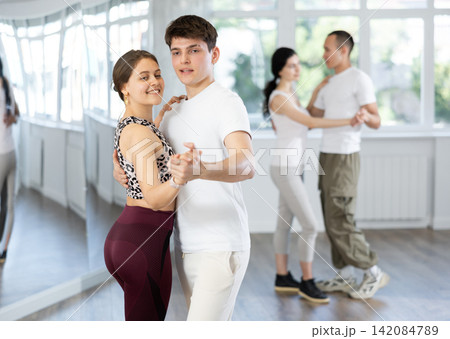 Young girl learning to dance waltz with guy partner in studio 142084789