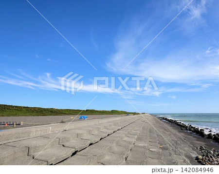 広い青空の下に続く海岸のコンクリート護岸と海辺の風景 広い青空の下に続く海岸のコンクリート護岸と海辺の風景 142084946