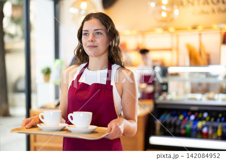 Seller carries a tray with cups of coffee 142084952