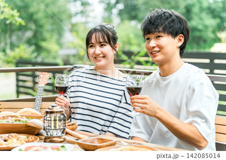 ウッドデッキ,テラス席,バルコニー席で食事するカップル,夫婦（グランピング・ベランピング） 142085014