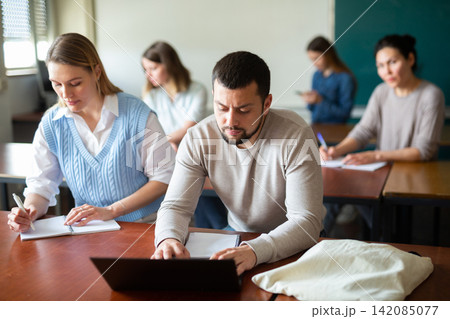 Two students studies on a laptop and writes a synopsis 142085077