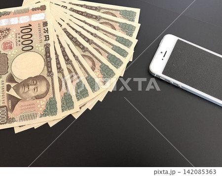 スマートフォンとお金・紙幣（黒バック） 142085363