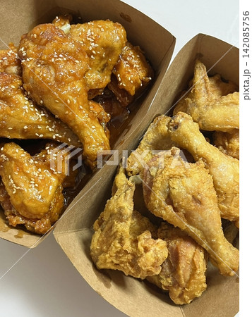 Crispy Korean fried chicken, perfectly glazed with a sweet and spicy sauce. Ideal for food photography and menus, showcasing the irresistible crunch and flavor of this beloved dish. Crispy Korean fried chicken, perfectly glazed with a sweet and spicy sauce. Ideal for food photography and menus, showcasing the irresistible crunch and flavor of this beloved dish. 142085756