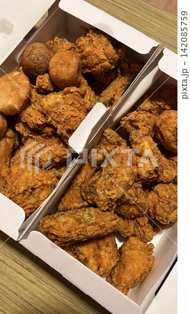 Crispy Korean fried chicken, perfectly glazed with a sweet and spicy sauce. Ideal for food photography and menus, showcasing the irresistible crunch and flavor of this beloved dish. 142085759
