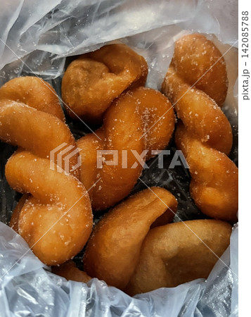 Golden and crispy kkwabaegi, Korean twisted donuts with a soft, fluffy interior, coated in sugar and cinnamon. A sweet and chewy treat perfect for snacking or dessert. Golden and crispy kkwabaegi, Korean twisted donuts with a soft, fluffy interior, coated in sugar and cinnamon. A sweet and chewy treat perfect for snacking or dessert. 142085788