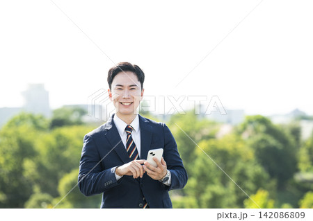 スマホを持つビジネスマン 142086809