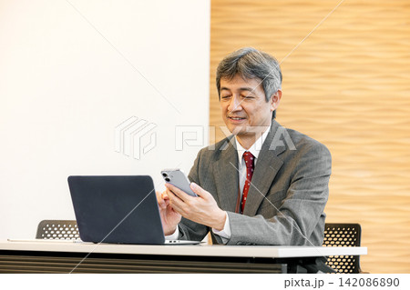スマホを使う中高年のビジネスマン スマホを使う中高年のビジネスマン 142086890