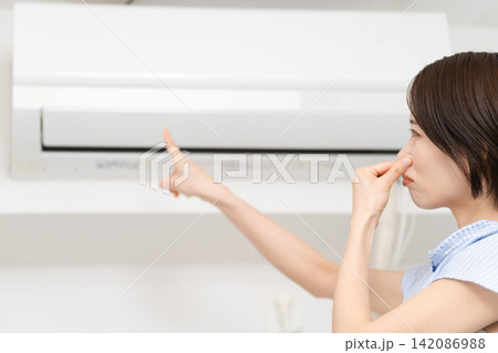 エアコンの匂いが気になる若い女性 ライフスタイルイメージ エアコンの匂いが気になる若い女性 ライフスタイルイメージ 142086988