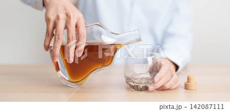 man pour cognac into a glass on table, suffering from alcohol addiction, alcoholism concept. depicting emotional distress, depression, substance abuse problem, unhealthy lifestyle and mental health man pour cognac into a glass on table, suffering from alcohol addiction, alcoholism concept. depicting emotional distress, depression, substance abuse problem, unhealthy lifestyle and mental health 142087111