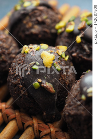 Homemade chocolate snacks with nuts on a woven tray 142087909
