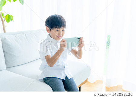 スマホを操作する小学生の男の子 スマホを操作する小学生の男の子 142088120