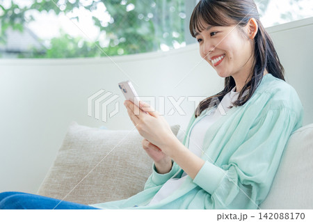 ソファーでスマホを使う女性 ソファーでスマホを使う女性 142088170