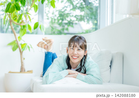 リビングでくつろぐ若い女性 リビングでくつろぐ若い女性 142088180