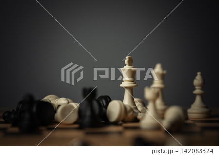 white chess king and various pieces scattered on wooden board white chess king and various pieces scattered on wooden board 142088324
