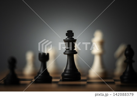 close-up of black chess king surrounded by blurred pieces on board 142088379