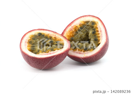 Ripe Passion Fruit Cut in Half Showing Yellow Pulp and Black Seeds on White Background Ripe Passion Fruit Cut in Half Showing Yellow Pulp and Black Seeds on White Background 142089236