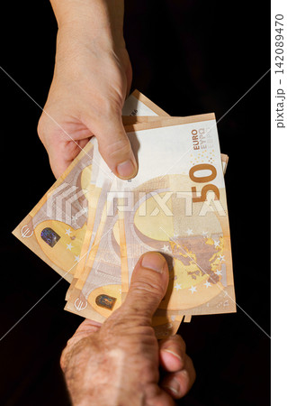 Hand giving euro fifty banknotes for payment Hand giving euro fifty banknotes for payment 142089470