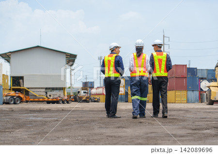 Workers discussing project at logistics yard with shipping containers for supply chain management. Workers discussing project at logistics yard with shipping containers for supply chain management. 142089696