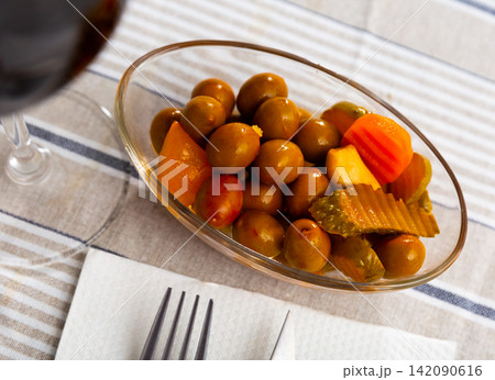 Tasty small serving of olives with carrots pickles and onions Tasty small serving of olives with carrots pickles and onions 142090616