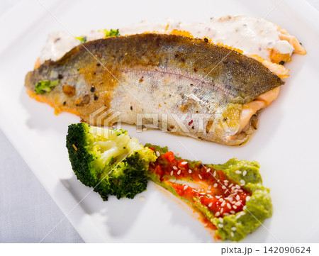 Tasty steak of fried river trout fillet with broccoli and sause tartar on plate 142090624