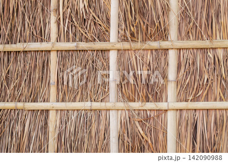 Natural bamboo frame dried palm leaf thatch forming rustic woven wall texture ideal for traditional architecture tropical design natural backgrounds Natural bamboo frame dried palm leaf thatch forming rustic woven wall texture ideal for traditional architecture tropical design natural backgrounds 142090988
