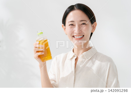 ペットボトルのお茶を飲む女性 142091298