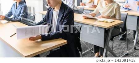 研修で資料を読むビジネスパーソン 142091418