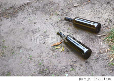 After party.Two empty wine bottles are lying on the ground After party.Two empty wine bottles are lying on the ground 142091740