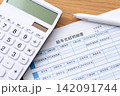 給与支給明細書と電卓 142091744