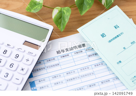 給与支給明細書と電卓 142091749