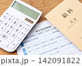 給与支給明細書と電卓 142091822