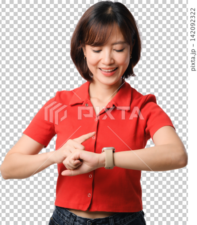Joyful cheerful Asian woman wearing red shirt pointing finger at smartwatch wrist looking down with happy smiling face expression 142092322
