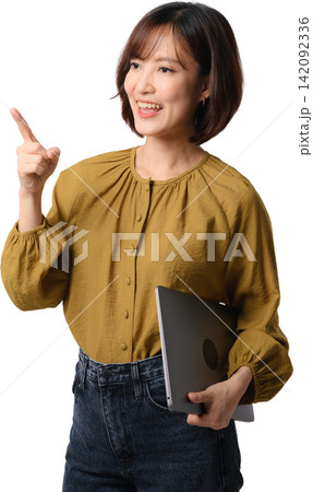 Happy cheerful asian woman pointing finger up holding laptop computer for presentation concept isolated on white studio background 142092336