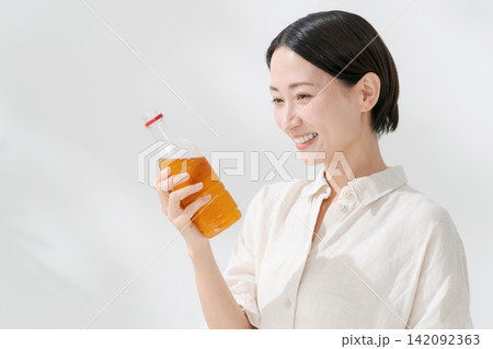 ペットボトルのお茶を飲む女性 142092363
