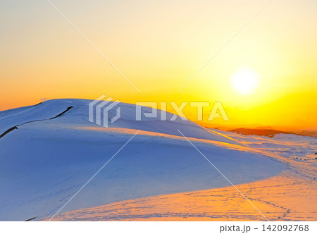 夕陽でオレンジ色に輝く雪の鳥取砂丘 夕陽でオレンジ色に輝く雪の鳥取砂丘 142092768