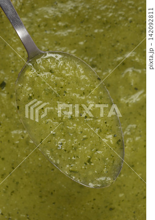 Spoonful of thick green zucchini cream soup close up Spoonful of thick green zucchini cream soup close up 142092811