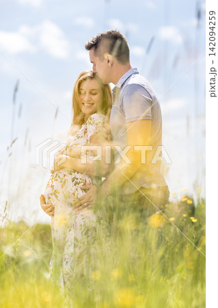 Young happy pregnant couple hugging in nature. Concept of love, relationship, care, marriage, family creation, pregnancy, parenting 142094259