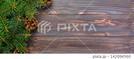 Christmas gray wooden background with fir tree frame and cones copy space. top view empty space for your design Christmas gray wooden background with fir tree frame and cones copy space. top view empty space for your design 142094560