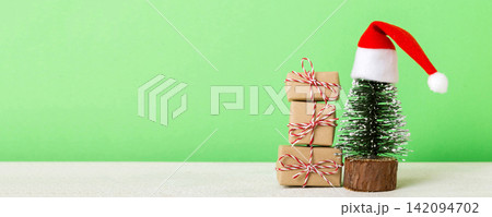 Christmas composition. Gifts, small tree, branches and craft DIY decorations on white background. New year concept. Christmas home decoration Flat lay, top view, copy space 142094702