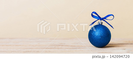 Christmas ball on colored background. decoration bauble with ribbon bow with copy space 142094720