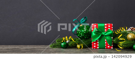 New Year Christmas mood, gift box, branches of a christmas tree, New Year decorations on a colored background New Year Christmas mood, gift box, branches of a christmas tree, New Year decorations on a colored background 142094929