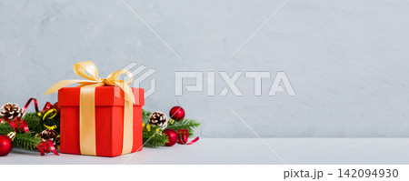 New Year Christmas mood, gift box, branches of a christmas tree, New Year decorations on a colored background New Year Christmas mood, gift box, branches of a christmas tree, New Year decorations on a colored background 142094930